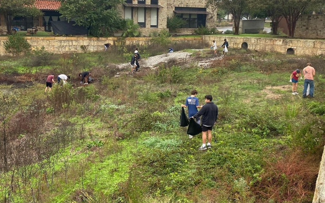 Green team students pick up trash polluting the Wag-A-Bag pond on their trash-pick up community service day. The students to pick up the most trash could win free ice cream as a reward.