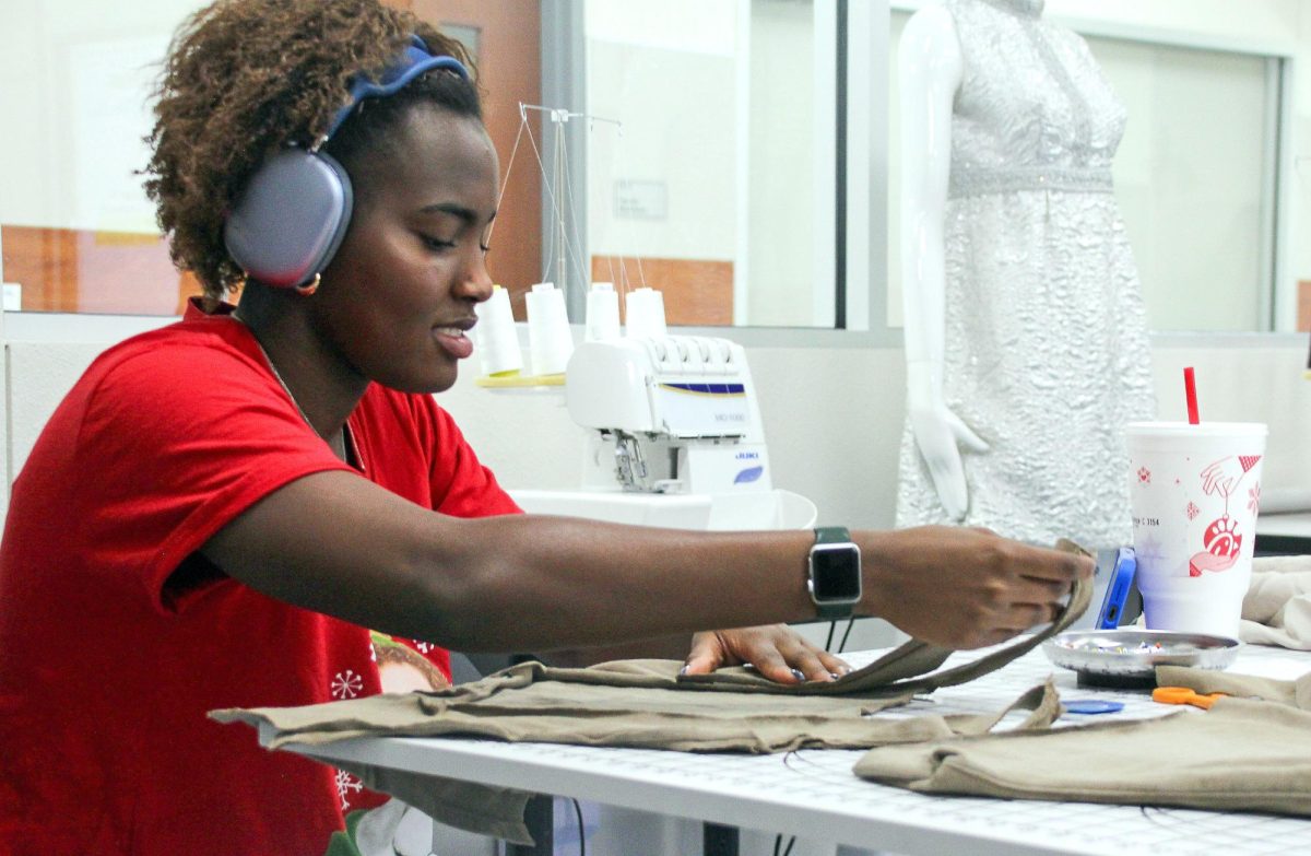Senior Kadence Carter lays out her pattern in Deanna Bentley's fashion design class.