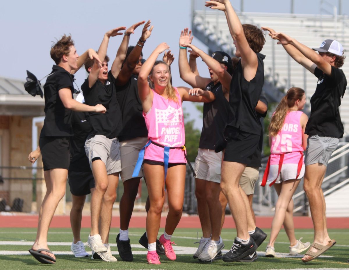 Senior Emma Winans celebrates with senior football players after scoring a touchdown. 