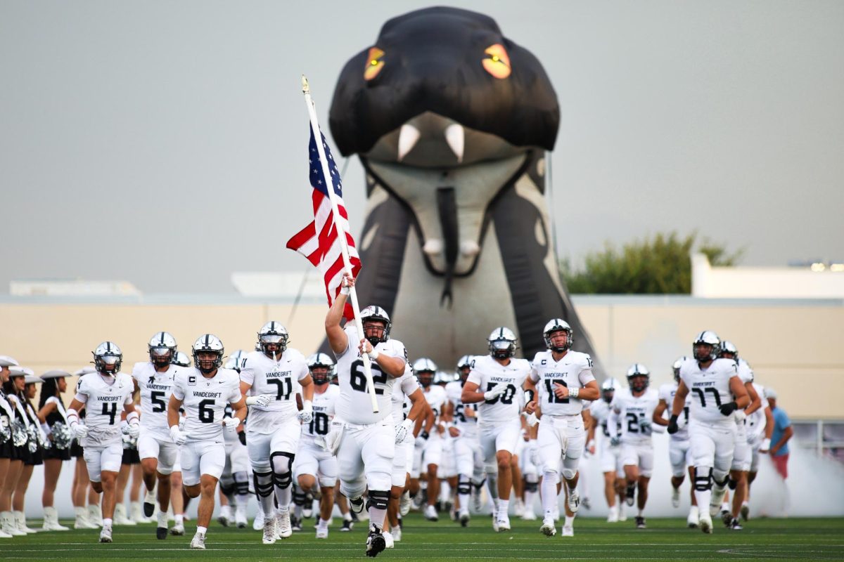 Senior Chase Springer carries the flag as varsity football team started the 2025 season at Dripping Springs, falling 41-14 in their season opener Aug. 29.