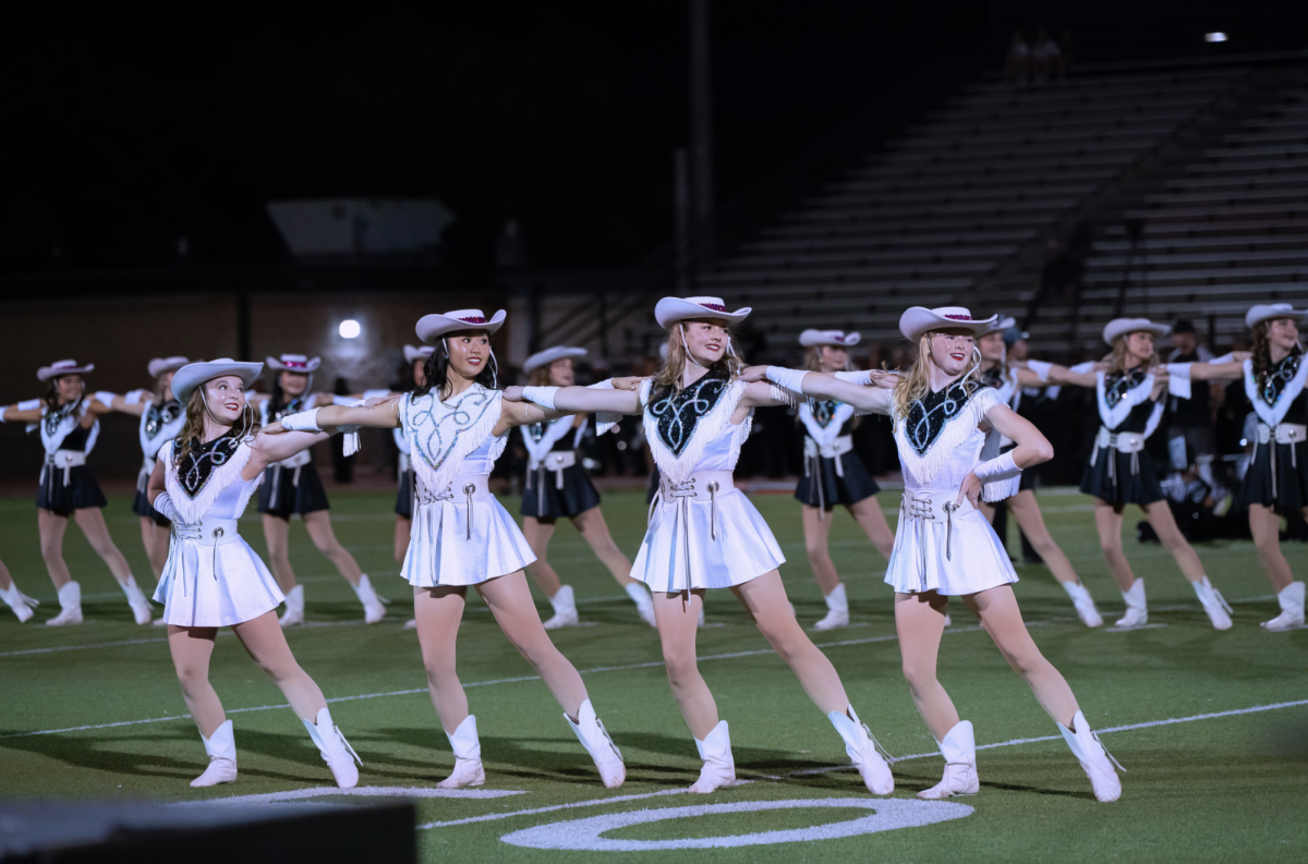 The Legacies perform their kick routine during halftime at the Cedar Ridge away game on Oct. 10. After performing, some members of the Legacies went to meet members of Cedar Ridge's drill team, and vice versa. 
Photo taken by Band and Vision Photographers.