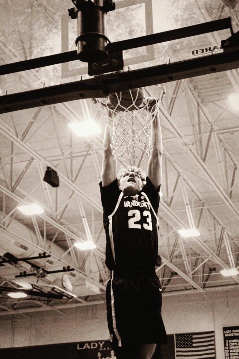 Junior Maxton Boyer goes up for a dunk while warming up for the second half of the game. 