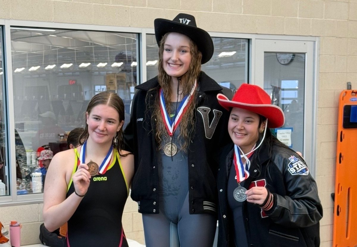 Bisque receives the gold medal for first place in the 100-meter backstroke.