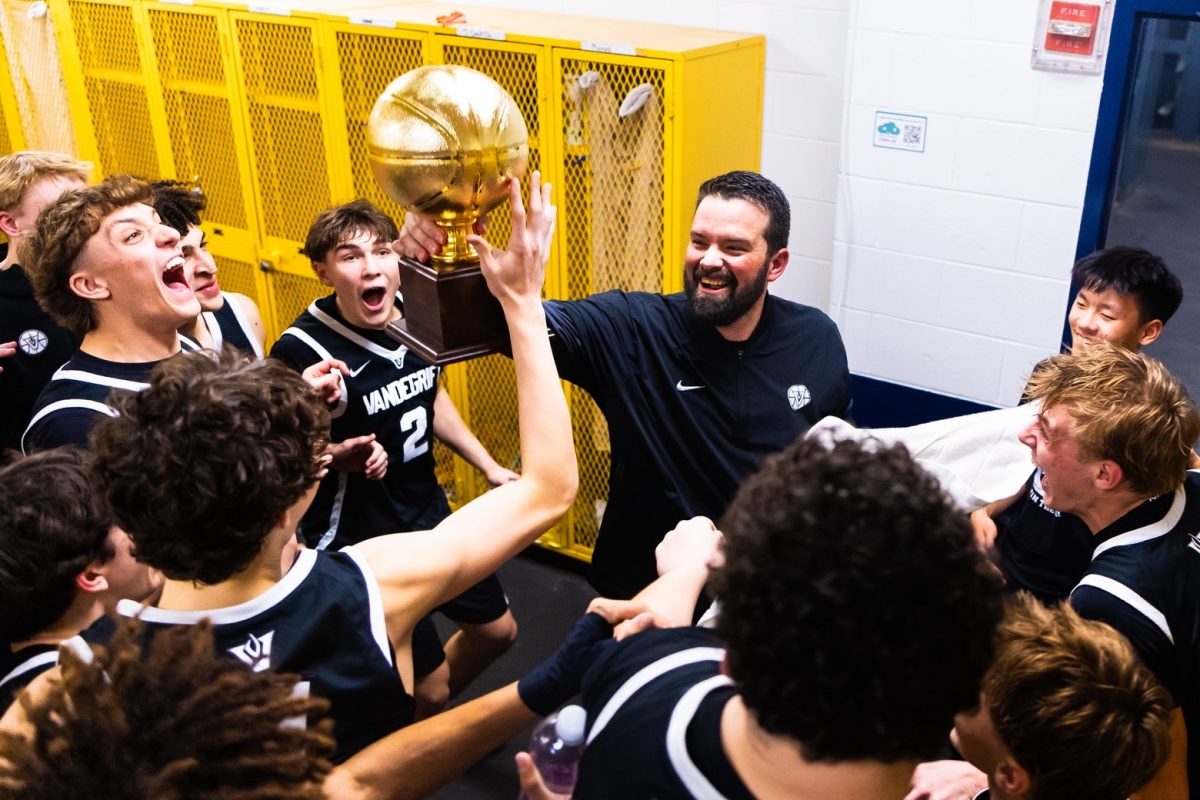 Head coach Jaime Sierra hoists up the bi-district playoff trophy after a 66-40 win over Austin High in the opening round of playoffs at Stony Point on Feb. 24. 