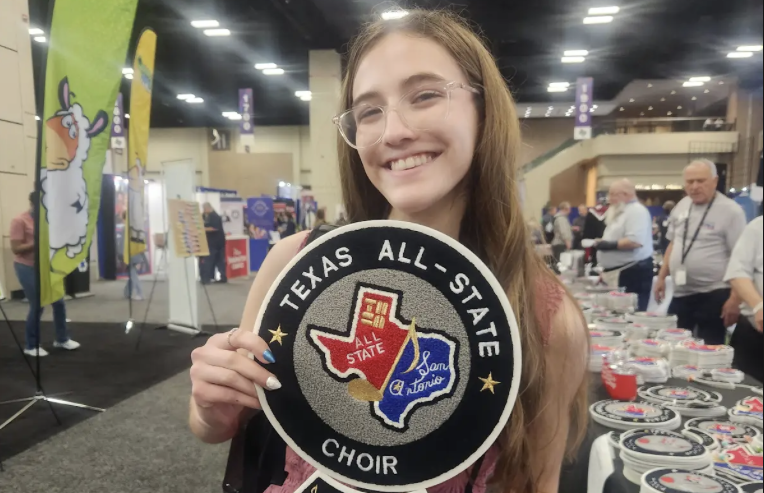Junior Maya Leach showcases a large all-state choir patch she purchased during the convention.