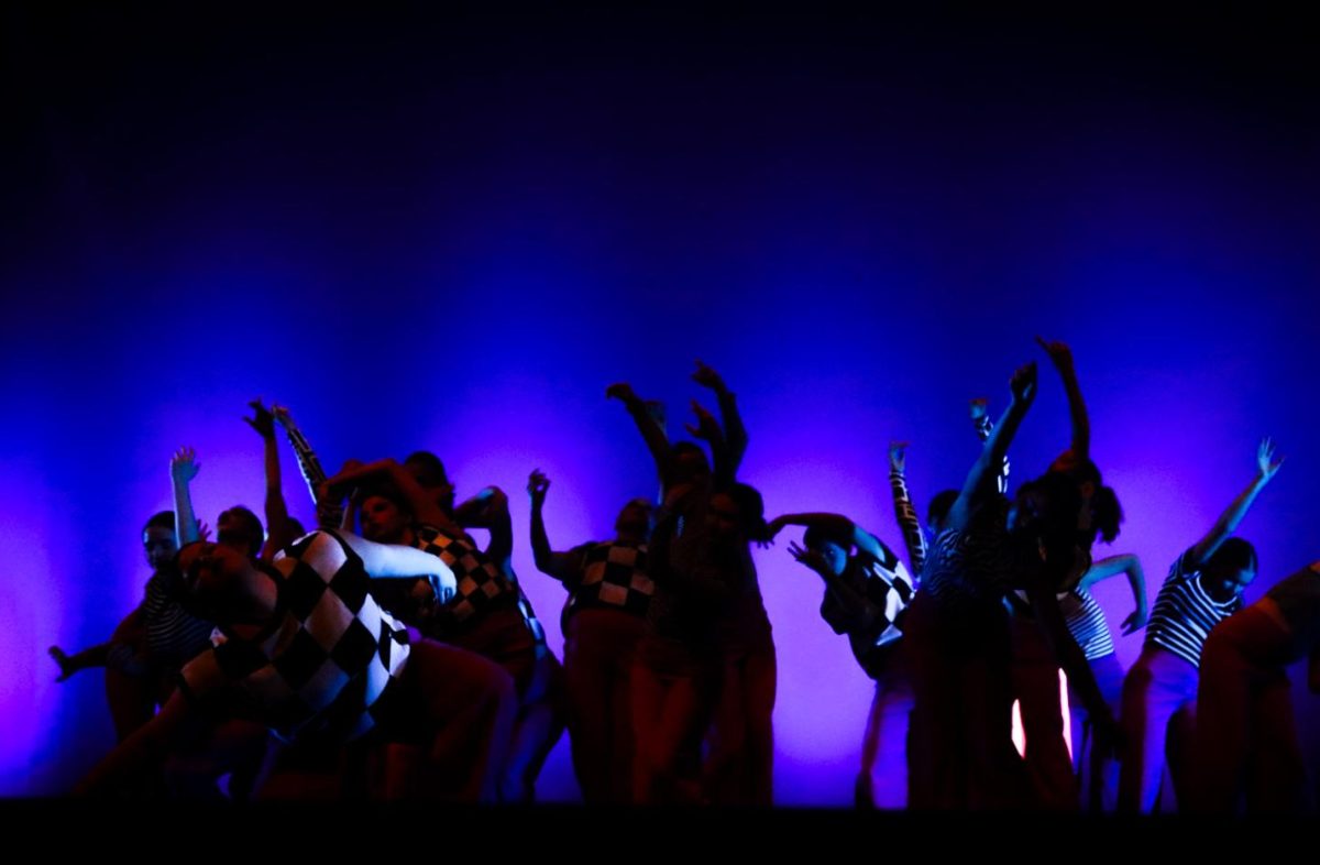 Dancers move in unison with extended arms and angled poses during their modern routine at the Visionary showcase. 