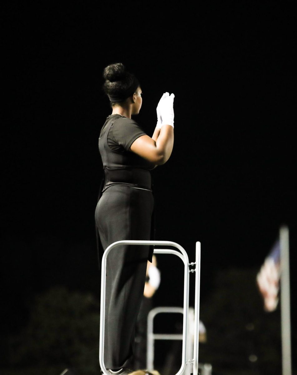Senior Saron Amsalu directs her fellow bandmates through the halftime performance of a football game. Amsalu acted as a drum major in the show, “Gaia’s Embrace,” which placed earned the bronze medal at the state competition.